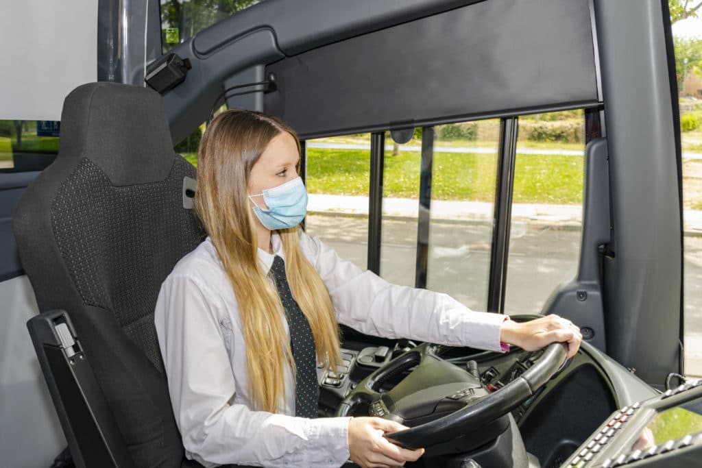 female bus driver wearing mask on bus