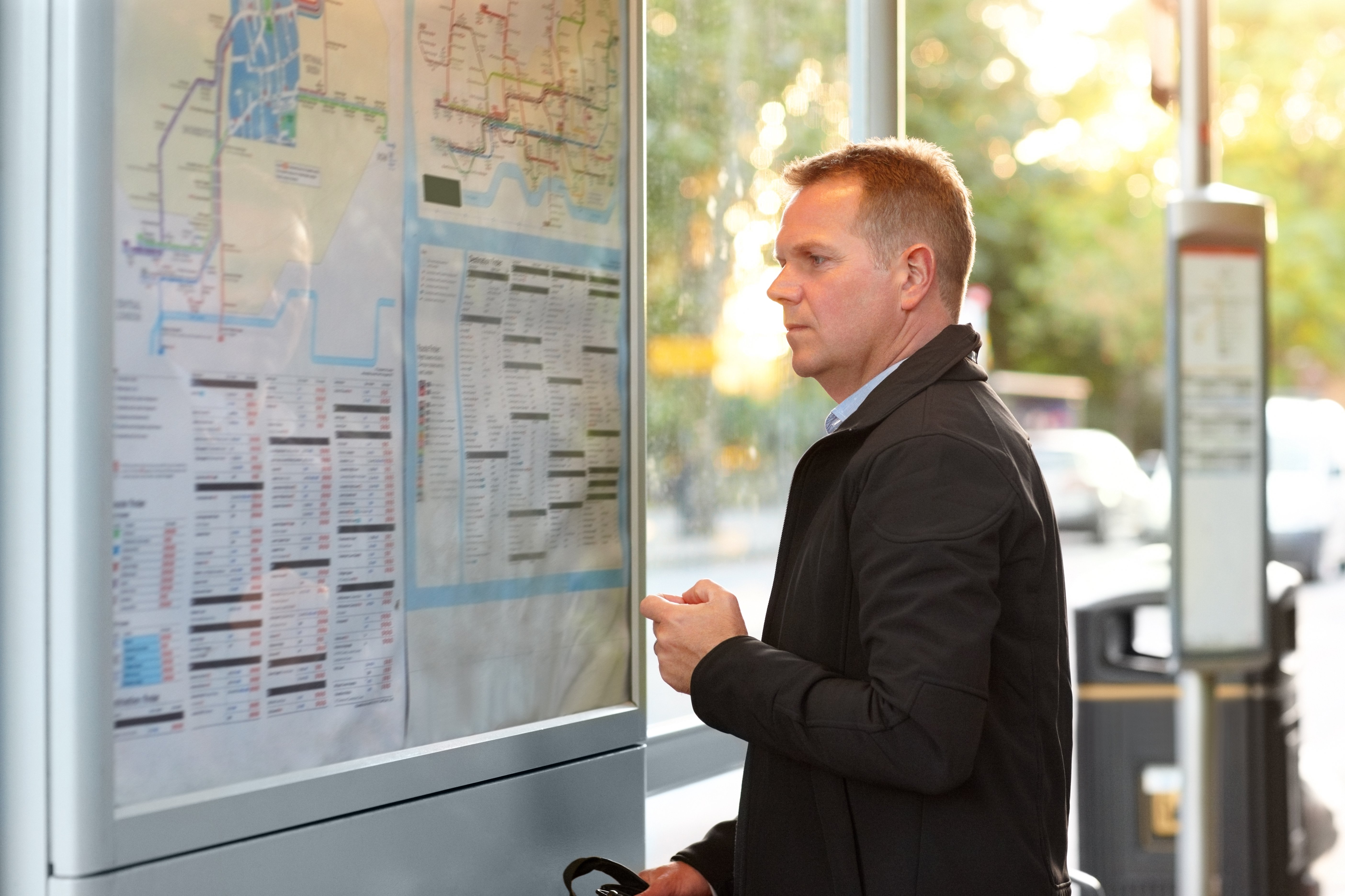 Passenger looks at bus schedule GettyImages-472092151